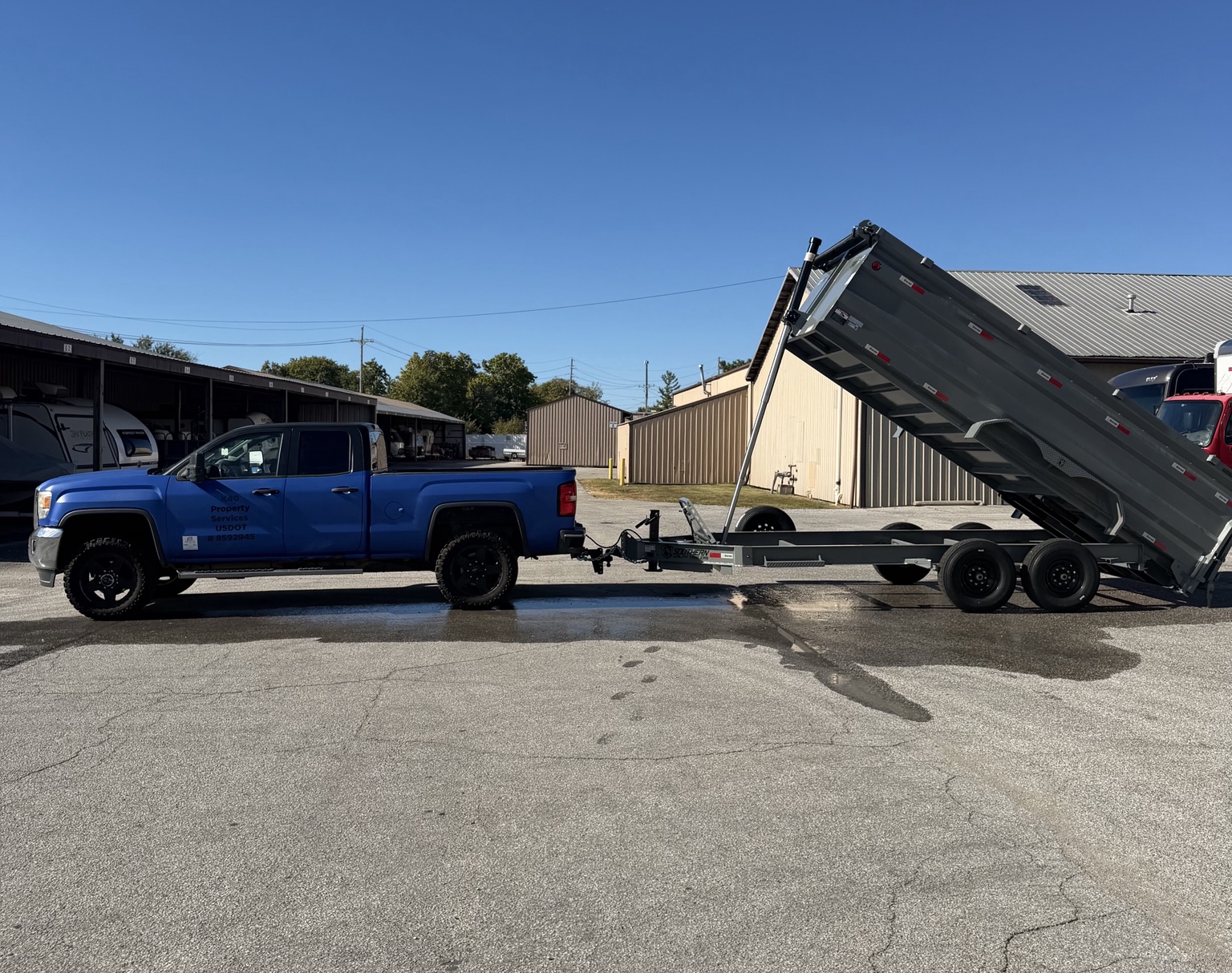 K40's blue GMC truck connected to its raised dump trailer